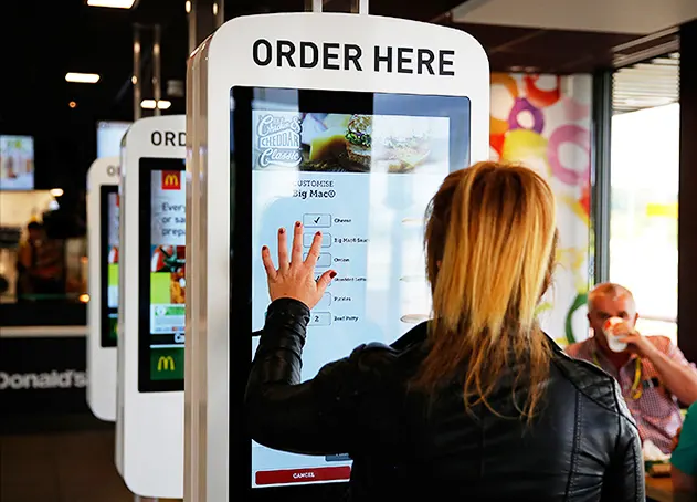 people using a standing kiosk to order