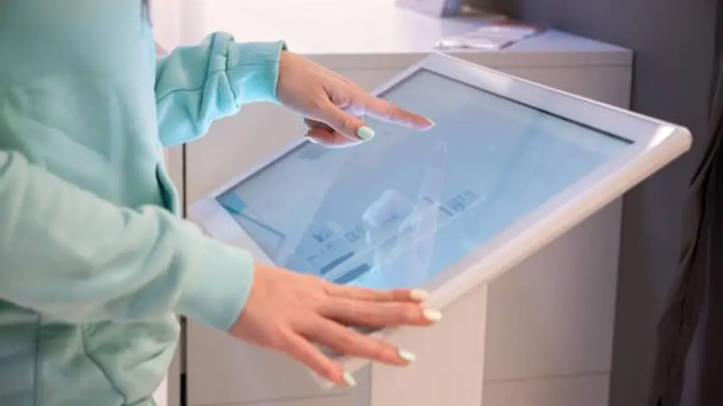 Faceless Woman Touching The Screen Of A Self Service Device In A Store.